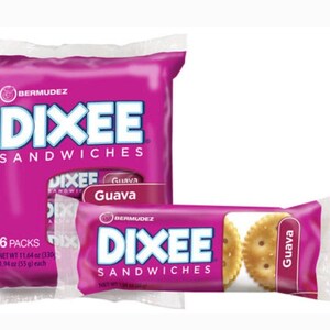 Op de afbeelding: Een grote magentakleurige verpakking van Bermudez Dixee Guava Sandwiches met 6 pakjes, met een nettogewicht van 330g, naast een enkel individueel snackpakje met hetzelfde merk en een zichtbaar rond koekje met guavevulling.