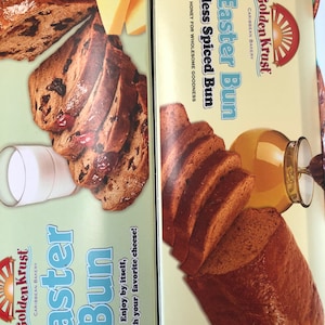 Può includere: Una scatola di Golden Krust Ital Easter Bun Fruitless Spiced Bun del panificio caraibico Golden Krust. La scatola presenta una foto del pan, che è di colore marrone scuro e ha un sapore dolce e speziato. Il pan è fatto con il miele per una bontà salutare. La scatola presenta anche il logo Golden Krust e le parole "Ital Easter Bun" e "Fruitless Spiced Bun".