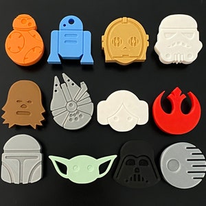 May include: A set of 12 Star Wars character themed buttons. The buttons are made of plastic and feature a variety of characters, including Darth Vader, Yoda, R2-D2, and Chewbacca.