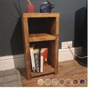 May include: A two-shelf wooden bookcase with a rustic brown finish. The bookcase is made of reclaimed wood and has a natural, distressed look. It is 76 cm tall and 30 cm wide. The bookcase is shown with books on the shelves and a small decorative item on the top shelf.