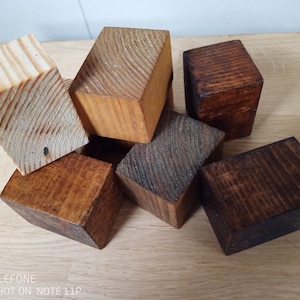 May include: A group of five wooden blocks in various shades of brown. The blocks are arranged in a random pattern, with some blocks stacked on top of others.
