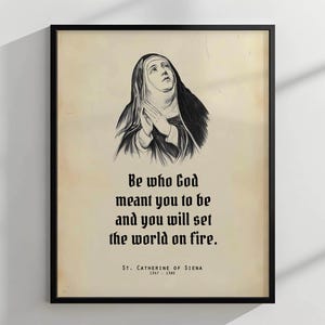 Puede incluir: Impresión enmarcada en negro con una ilustración en blanco y negro de una mujer con hábito religioso, con las manos juntas. La impresión muestra la cita "Sé quien Dios quiso que fueras y prenderás fuego al mundo." y el nombre "Santa Catalina de Siena".
