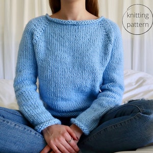 May include: A light blue knitted sweater with a round neckline and long sleeves. The sweater is made with a simple stitch pattern and has a relaxed fit.