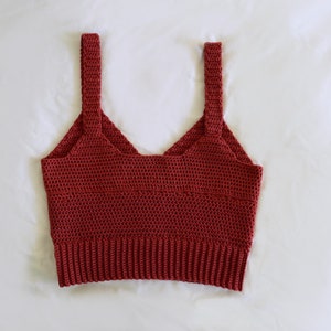 May include: A red crocheted tank top with thin straps.