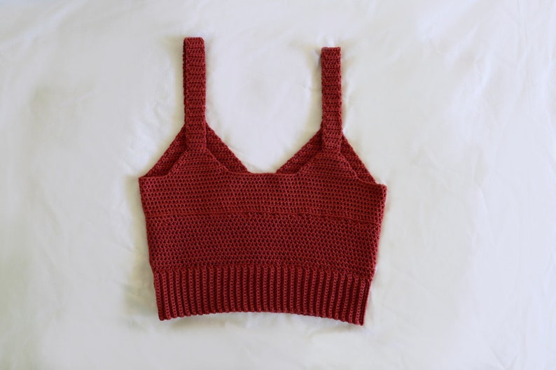 May include: A red crocheted tank top with thin straps.