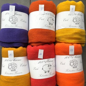 Pode incluir: Seis echarpes de l&atilde; enroladas em v&aacute;rias cores: roxo, laranja, amarelo e vermelho. Cada echarpe &eacute; rotulada com um n&uacute;mero e o texto "100% laine Etole Echarpe Fabrication Fran&ccedil;aise" com uma ilustra&ccedil;&atilde;o de ovelha.