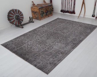 May include: A gray and white patterned rug with a floral design. The rug has a distressed look and is made of a soft, woven material.
