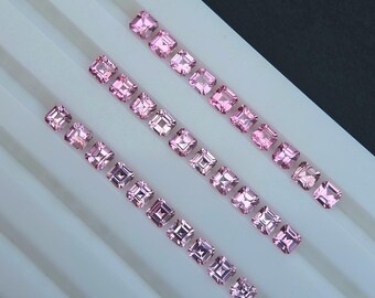Può includere: File di gemme rosa taglio quadrato disposte diagonalmente su una superficie bianca. Le gemme variano leggermente di dimensioni, con una tonalità rosa chiaro uniforme. La disposizione suggerisce una collezione di pietre preziose, forse per la creazione di gioielli.