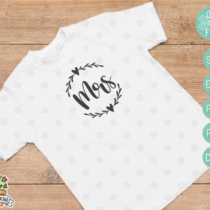 May include: White t-shirt with a black floral wreath design and the word "Mom" in a cursive font.