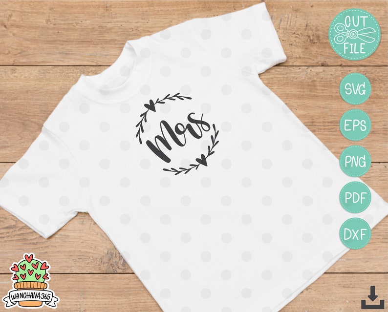 May include: White t-shirt with a black floral wreath design and the word "Mom" in a cursive font.