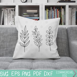 May include: A white throw pillow with three black line drawings of stylized leaves. The leaves are arranged vertically in a row in the center of the pillow.