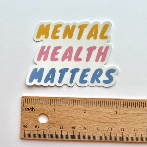 May include: A sticker with the words "Mental Health Matters" in a layered design. The words "Mental" are in yellow, "Health" are in pink, and "Matters" are in blue.