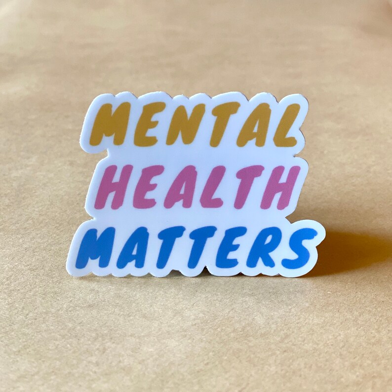 May include: A white sticker with the text "MENTAL HEALTH MATTERS" in bold, colorful letters. The words "MENTAL" are in yellow, "HEALTH" are in pink, and "MATTERS" are in blue.