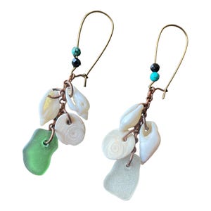 May include: A pair of dangle earrings featuring a copper chain and an assortment of white seashells, green and turquoise glass beads, and black beads.