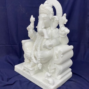 Op de afbeelding: Wit marmeren beeld van Ganesha, de hindoe&iuml;stische god van wijsheid en voorspoed, zittend op een troon met een muis aan zijn voeten.