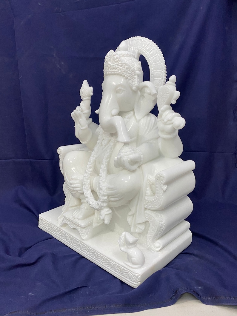 Op de afbeelding: Wit marmeren beeld van Ganesha, de hindoe&iuml;stische god van wijsheid en voorspoed, zittend op een troon met een muis aan zijn voeten.