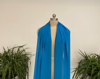 May include: A light blue sheer fabric draped over a dress form. The fabric is soft and flowing, and it would be perfect for making a dress, skirt, or blouse.