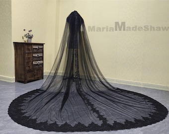May include: A black tulle wedding veil with a lace trim. The veil is long and flowing, and it is perfect for a gothic or alternative wedding.