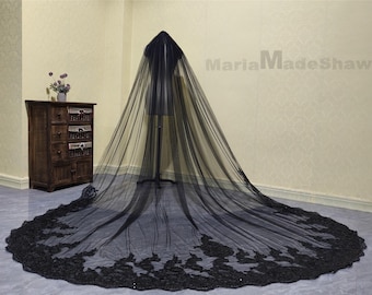 May include: A black wedding veil with a long, flowing train and delicate lace trim. The veil is made of soft tulle and is perfect for a gothic or alternative wedding.
