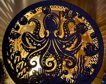 May include: A wooden, layered octopus lamp with a circular design. The lamp features an octopus in the center, surrounded by fish and seaweed cutouts. The lamp emits a warm, inviting glow, creating a unique decorative piece. The lamp is approximately 10 inches in diameter.