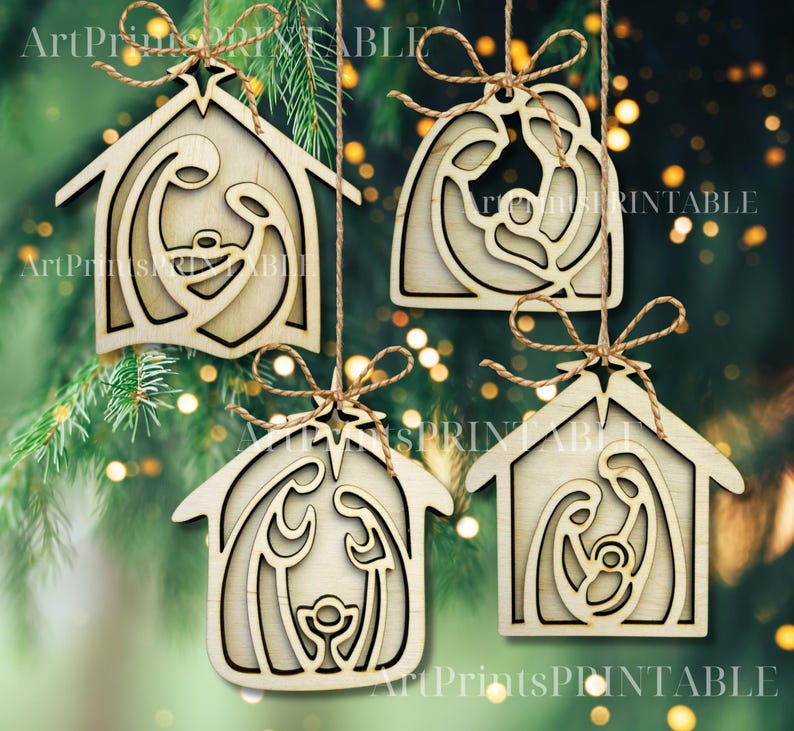 May include: Four wooden Christmas ornaments with a nativity scene design. Each ornament is a different shape, with a natural wood finish and a twine hanger. The ornaments are hanging against a blurred green background with bokeh lights.
