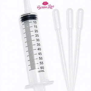 May include: A clear plastic syringe with black markings and a capacity of 60 cc/mL, accompanied by three clear plastic droppers. The syringe has a plunger and a measurement scale. The Barbie Lips logo is visible in the upper right corner.