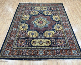 May include: A traditional Persian rug with a navy blue background and intricate patterns in shades of red, yellow, and blue. The rug features a central medallion with a geometric design and a border with repeating motifs.