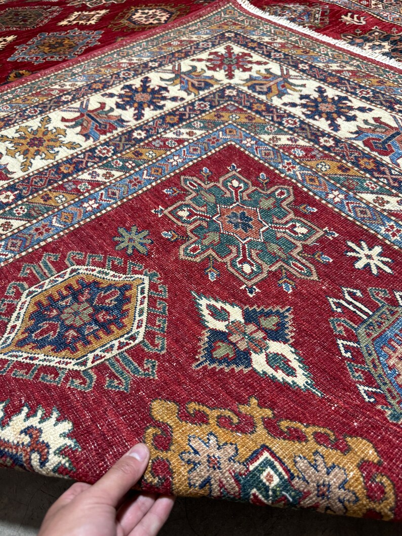 May include: A red, blue, and green patterned rug with intricate designs. The rug has a traditional Persian style and is made of wool.