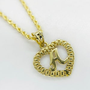 May include: A gold necklace with a heart-shaped pendant featuring the letter 'A' in a cursive font.