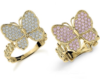 May include: Two gold butterfly rings with clear and pink cubic zirconia stones. The rings have a detailed band design.