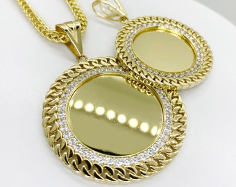 May include: Two gold pendant necklaces with round, clear-stone encrusted frames. The pendants are on a gold chain.