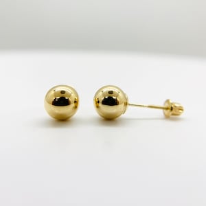 May include: A pair of gold ball stud earrings. The earrings are simple and classic, and they would make a great gift for any occasion.