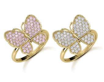 May include: Two gold butterfly rings with clear and pink cubic zirconia stones. The rings are set on a white background.