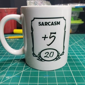 May include: White ceramic mug with a black design that says "SARCASM +5 20".