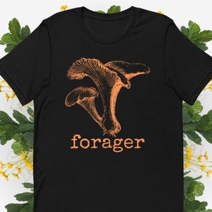 May include: Black t-shirt with an orange illustration of mushrooms and the word "forager" printed in orange.