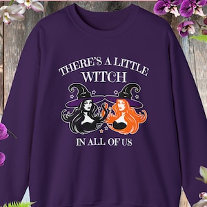 May include: Purple sweatshirt with a white graphic of two witches with the text "There's a little witch in all of us".