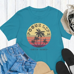 Pogue LIFE Outer Banks OBX Unisex Tee Shirt | Poguelandia John B Sarah Cameron JJ Pope Kiara | Sunset Palm Tree North Carolina Beach Vibes
