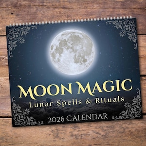 May include: A spiral-bound calendar titled "MOON MAGIC" with a full moon graphic against a starry night sky. The calendar also includes the text "Lunar Spells & Rituals" and "2026 CALENDAR" in gold and white lettering, with decorative flourishes.