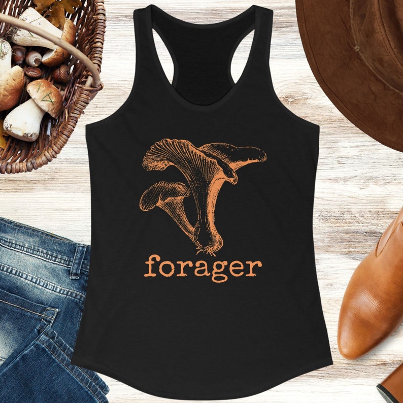 Puede incluir: Camiseta de tirantes negra con un gr&aacute;fico de setas naranjas y la palabra "forager" en naranja.