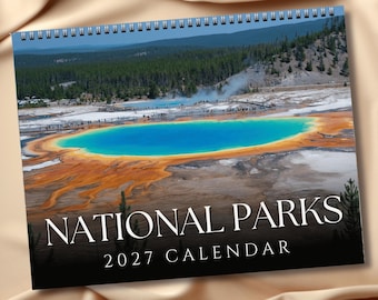 May include: A spiral-bound wall calendar featuring a photograph of the Grand Prismatic Spring with its vibrant blue center and orange-rimmed edges. The text NATIONAL PARKS 2027 CALENDAR is printed in white serif font against a black background at the bottom.