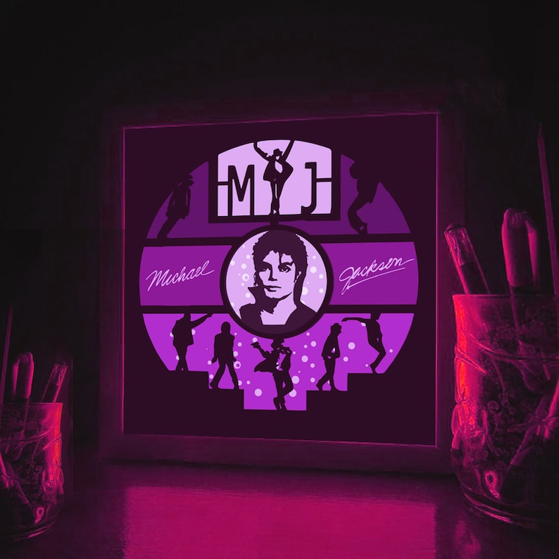 K&ouml;nnte beinhalten: Ein gerahmtes beleuchtetes Kunstwerk mit einer Silhouette von Michael Jackson mit dem Text "MJ" und "Michael Jackson" in einem lila und wei&szlig;en Farbschema.