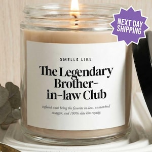 May include: A lit scented candle in a clear glass jar with a black lid. The label reads "The Legendary Brother-in-law Club." A purple starburst sticker says "NEXT DAY SHIPPING."