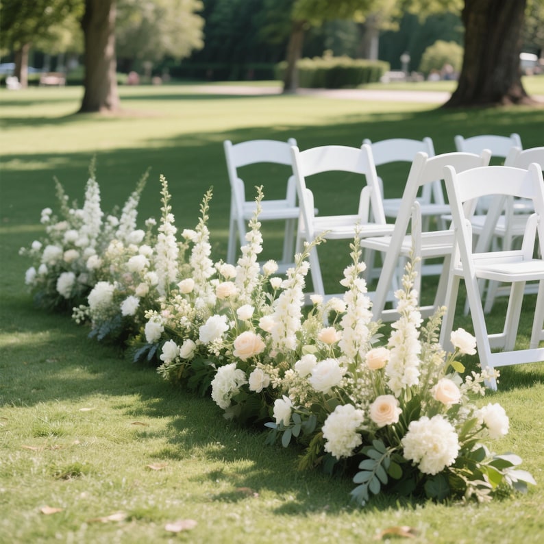 Puede incluir: Montaje para una ceremonia de boda al aire libre, con filas de sillas plegables blancas sobre un c&eacute;sped. Un arreglo floral de flores blancas y melocot&oacute;n bordea el pasillo, creando un ambiente natural y elegante para el evento.