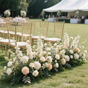 Puede incluir: Una ceremonia de boda al aire libre con sillas doradas y cojines color crema. Un exuberante arreglo floral de flores blancas y melocot&oacute;n bordea el pasillo, con una carpa blanca al fondo.