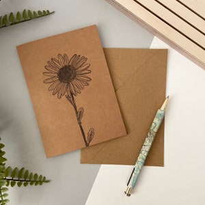 Carte de naissance d'une marguerite d'avril - Carte de voeux kraft A6, dessinée à la main et imprimée sur du papier cartonné recyclé