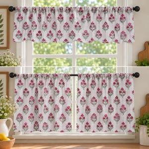 May include: A window curtain set featuring a repeating floral pattern with magenta pink flowers and sage green leaves on a light off-white background. The set includes a single valance and two matching panels, all hung on black curtain rods.