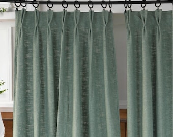 May include: A pair of green linen curtains with pleats hanging from a black curtain rod.