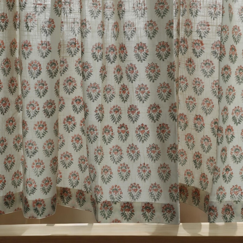 May include: White sheer curtains with a repeating pattern of small pink and green floral designs.