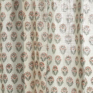 May include: White fabric with a repeating pattern of small, green and pink floral designs.