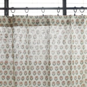 May include: White sheer curtains with a delicate floral pattern in shades of pink and green. The curtains are hung on a black rod with silver hooks.